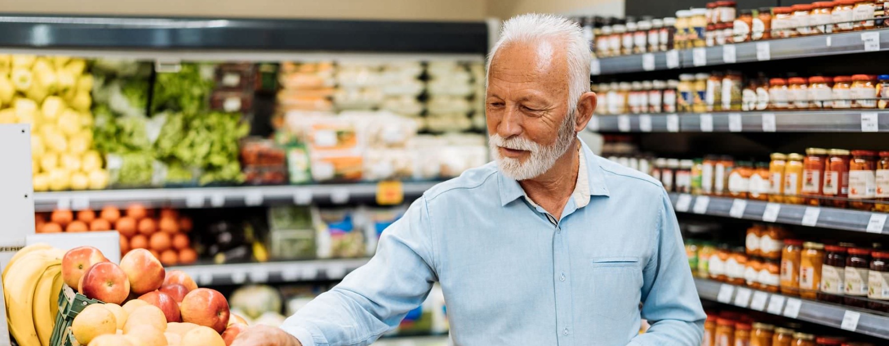 a person holding a shopping cart in a grocery store